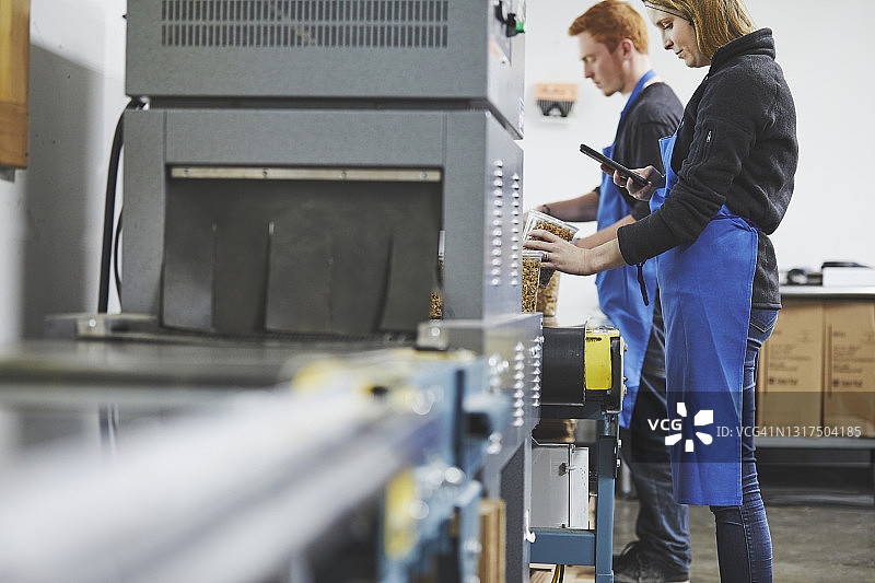 在工厂扫描腰果盒上二维码的女工图片素材