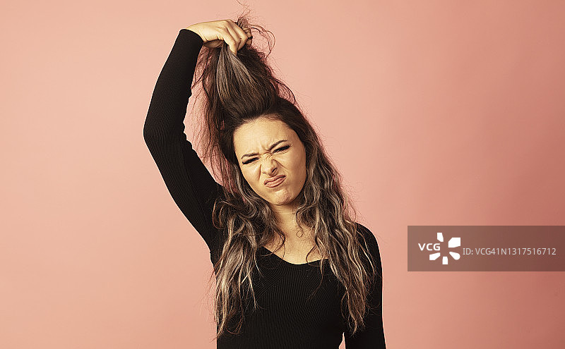年轻女子懊悔地用手捂着头发图片素材