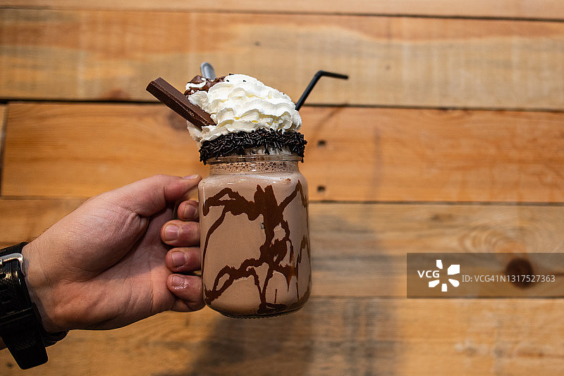 手持一杯巧克力奶昔图片素材