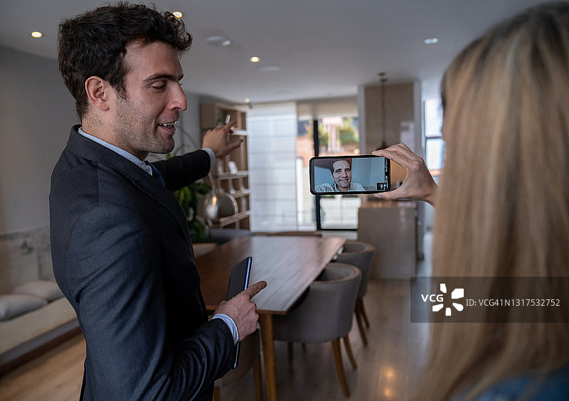 房地产经纪人向正在视频通话的女士展示房屋图片素材
