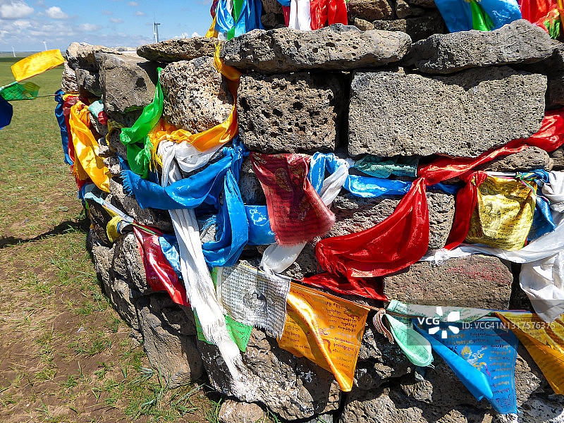 锡林浩特：内蒙古锡林浩特广阔牧场上的敖包，带有彩色祈祷旗图片素材