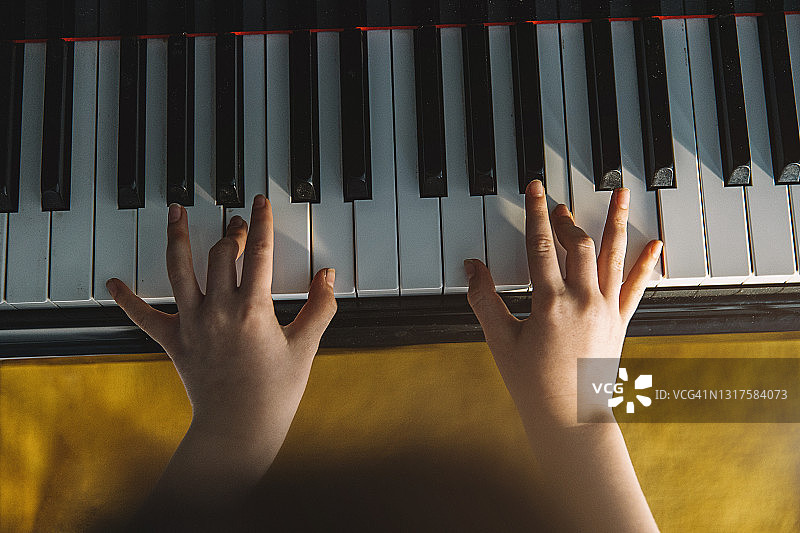 俯视角度拍摄的弹钢琴的儿童图片素材
