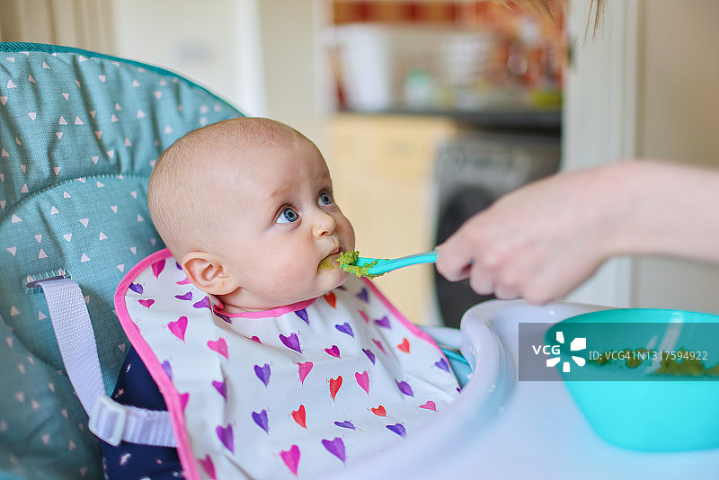 女婴第一次尝试西兰花泥图片素材