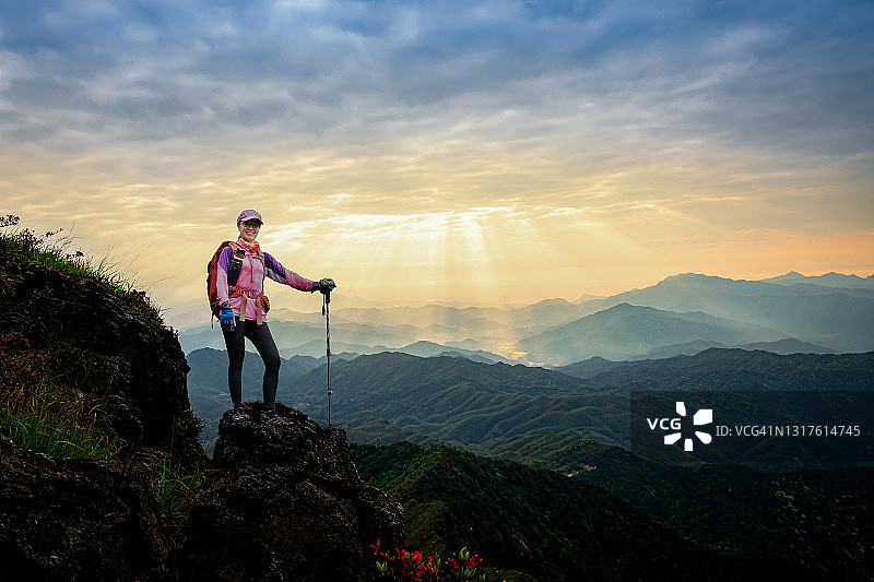 年轻亚洲女性在山顶日落时分休息图片素材