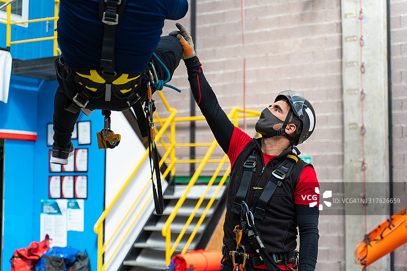 讲师在绳索上给学生讲解攀岩课程图片素材
