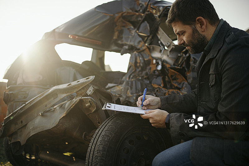 事故车辆旁正在工作的汽车保险代理人图片素材