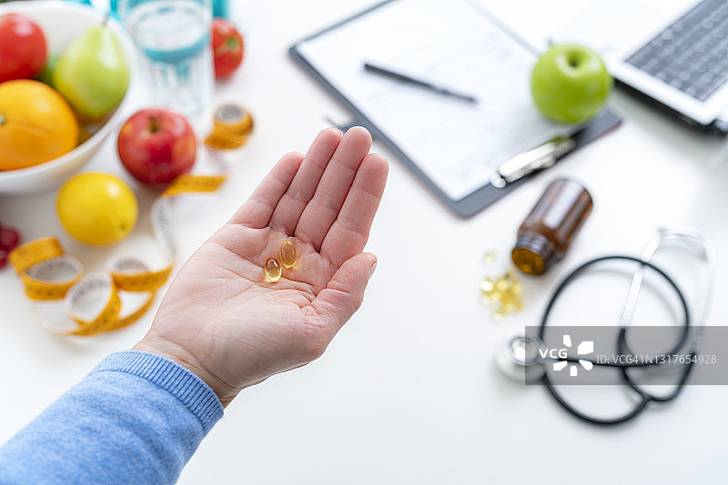 女人在营养师办公室手持营养补充剂图片素材