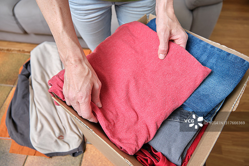 女子在家整理捐赠衣物图片素材