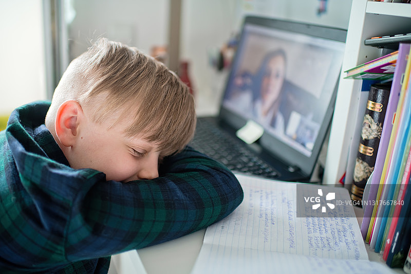 孩子在上网络课程时玩智能手机游戏，感到无聊图片素材