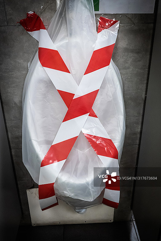 公共厕所内用胶带确保社交距离的封闭式小便池图片素材