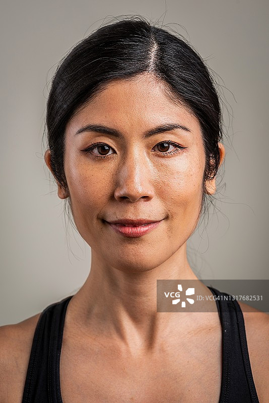 微笑的亚洲中年妇女看着镜头图片素材