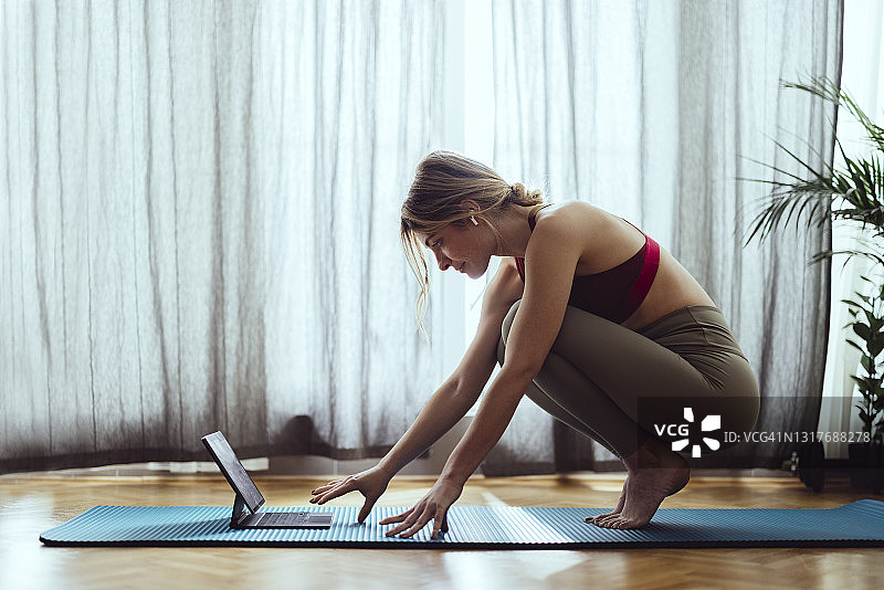 健身女人在平板电脑上看训练视频图片素材