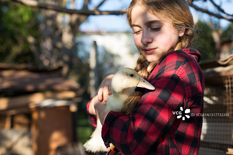 拿着小鸭子的年轻女孩图片素材