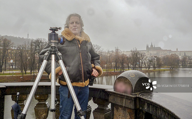 摄影师在伏尔塔瓦河上的桥上使用三脚架-捷克共和国布拉格图片素材