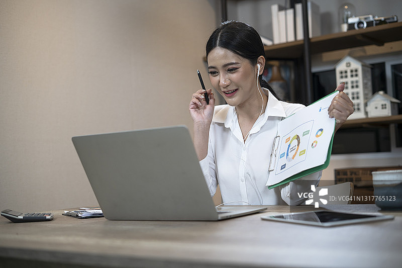 年轻女商人在家里的客厅里用笔记本电脑进行视频会议图片素材