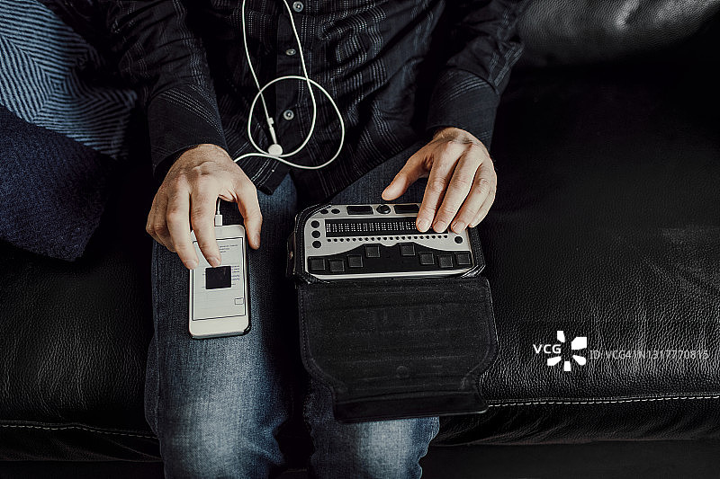 男人使用盲文键盘和智能手机图片素材