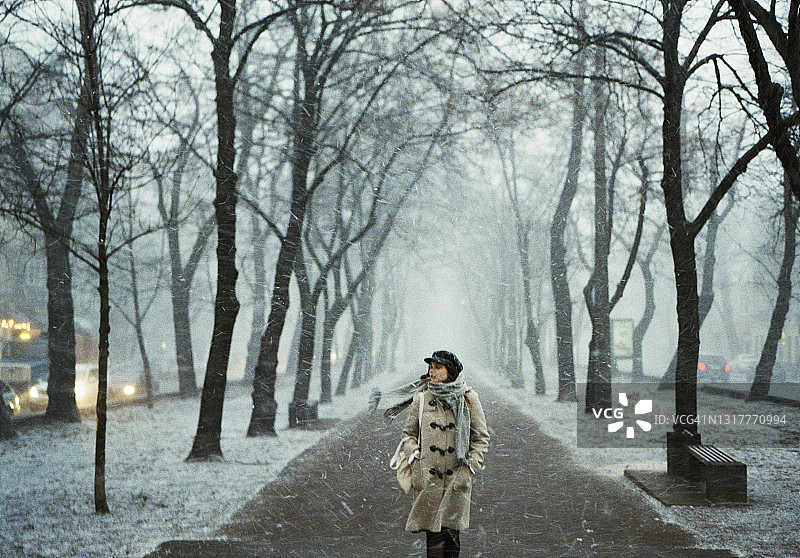 暴风雪中在城市里行走的女人图片素材