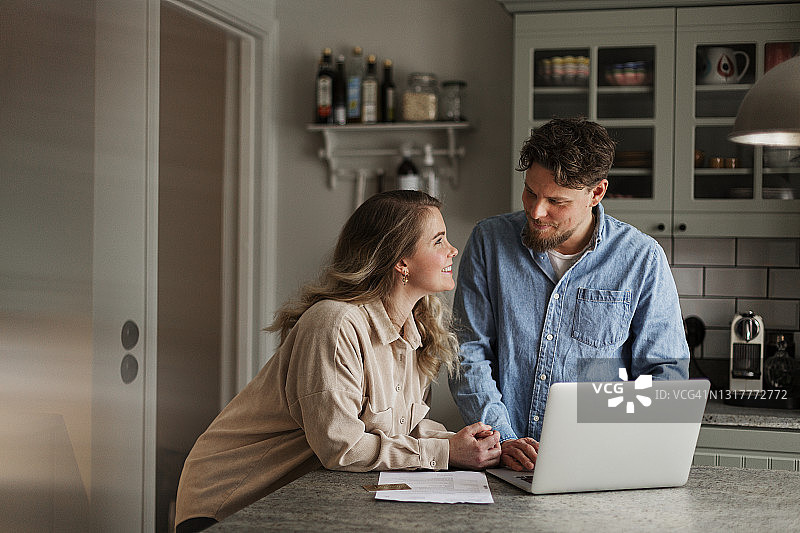 夫妇在家里使用笔记本电脑图片素材