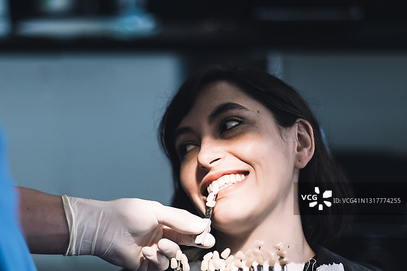 牙医使用牙科模型为患者选择合适的牙模图片素材