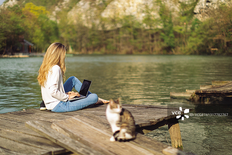 年轻女人在户外使用笔记本电脑图片素材