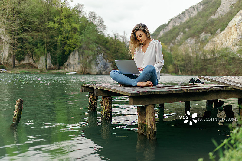 年轻女人在户外使用笔记本电脑图片素材