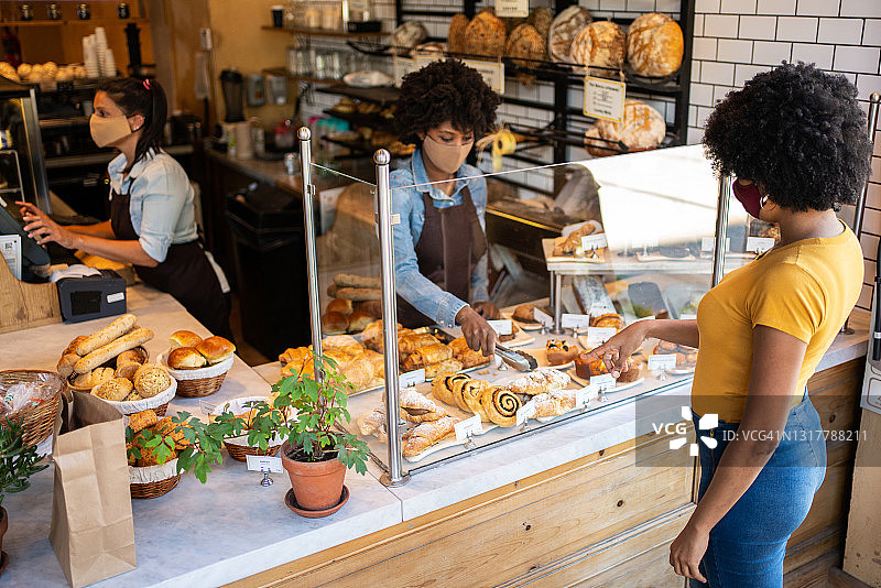 女顾客在面包店选择烘焙产品图片素材