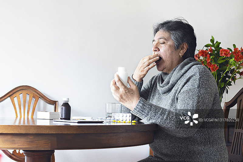 拉丁裔老妇在家吃药图片素材