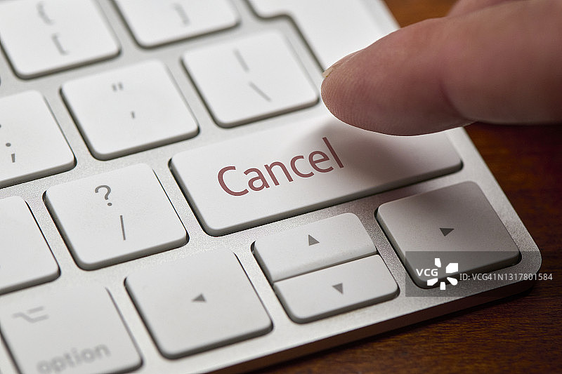 手指按下电脑键盘上的“取消”按钮图片素材