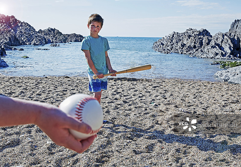 男孩在前景拿着球打棒球图片素材