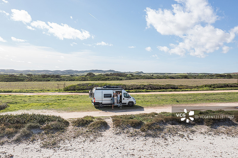 偏僻道路上的厢型车与享受自然的夫妇航拍图片素材