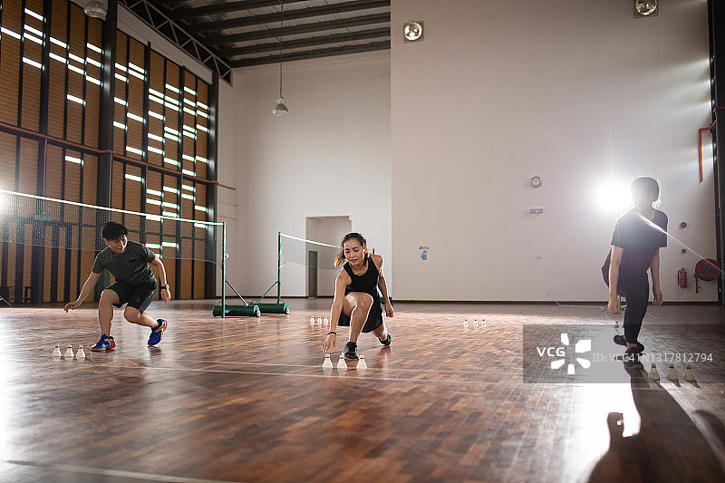 亚洲华裔羽毛球运动员在羽毛球场进行热身耐力训练图片素材