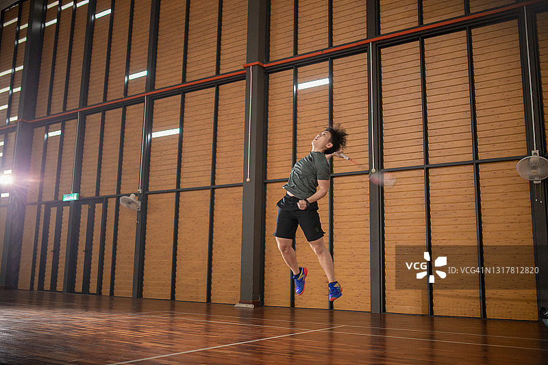 在羽毛球场上打羽毛球的亚裔华人图片素材