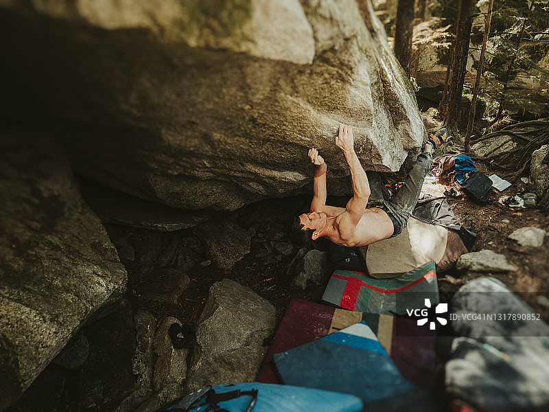 强壮男子攀爬花岗岩巨石图片素材