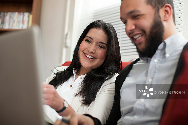 年轻情侣在家使用笔记本电脑图片素材