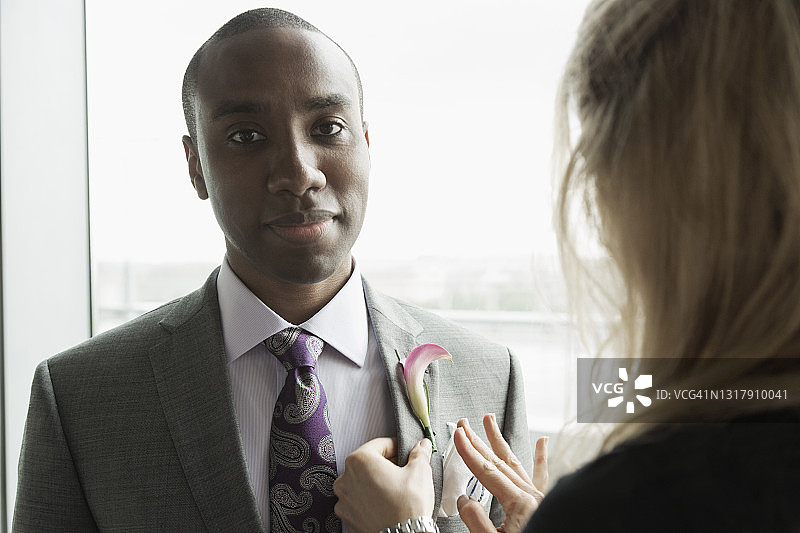 新郎在朋友的帮助下准备图片素材