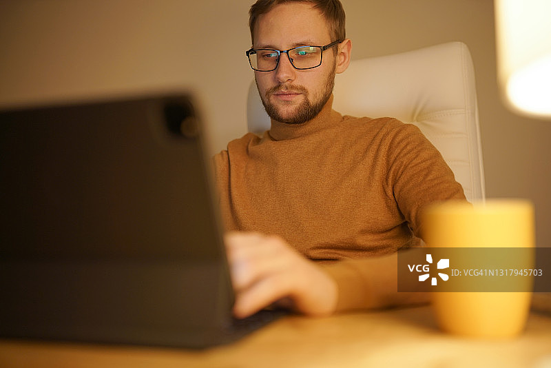 在家办公的舒适时光：暖光、平板和黄色马克杯图片素材