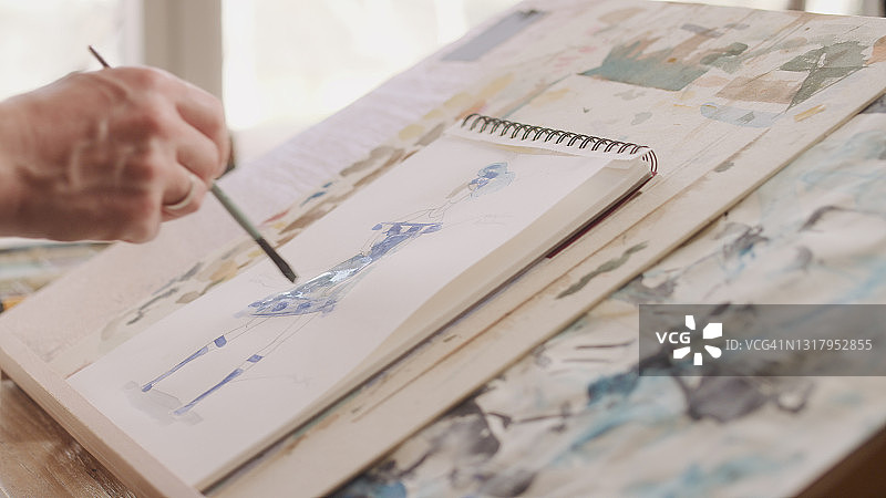 时装绘画草图，男性时装设计师工作时手部特写图片素材