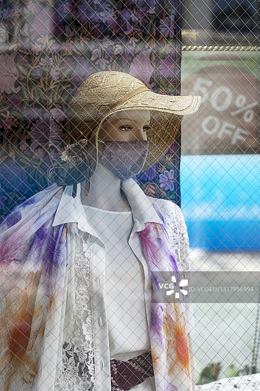 橱窗里戴着面具的女性人体模型图片素材