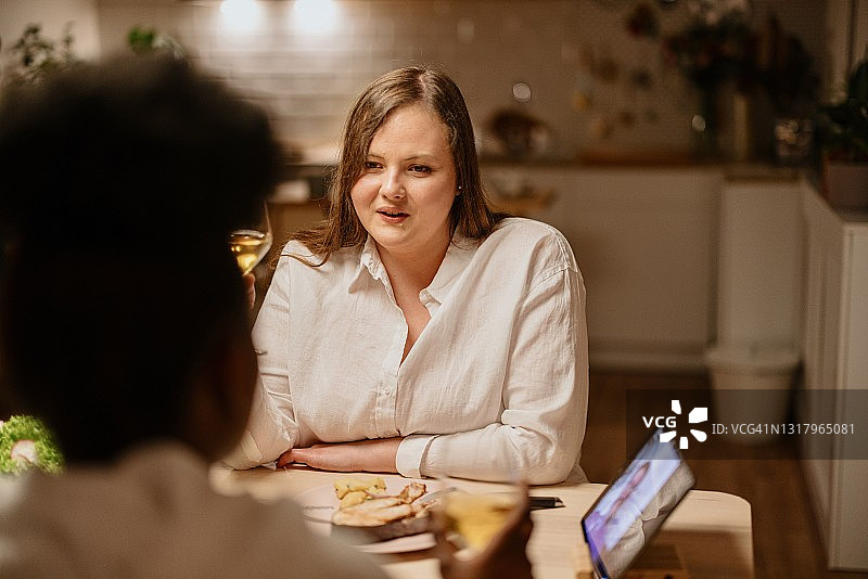 深夜，朋友们通过视频通话与共同的朋友共进晚餐图片素材