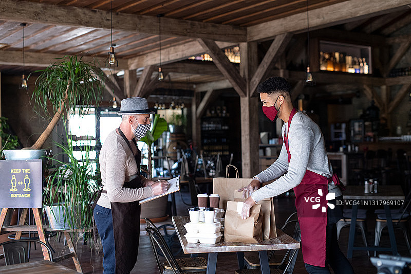餐厅服务员为顾客准备外卖食品，新冠疫情下的新常态概念图片素材
