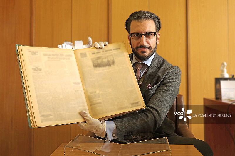 图书馆员阅读旧报纸图片素材