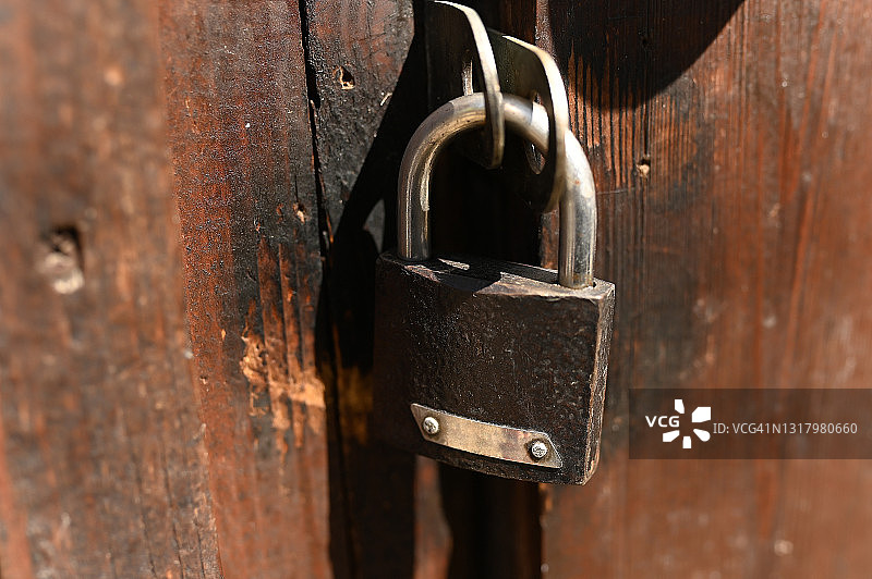 没有钥匙的谷仓锁挂在门上，紧闭的门，沉重感，锁住的门的概念，没有出口，停止，复制空间图片素材