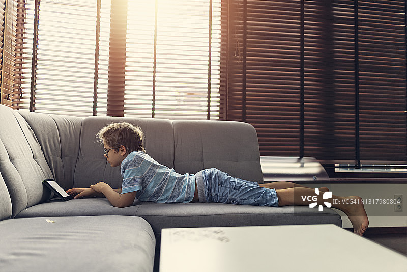 小男孩在家阅读电子书图片素材