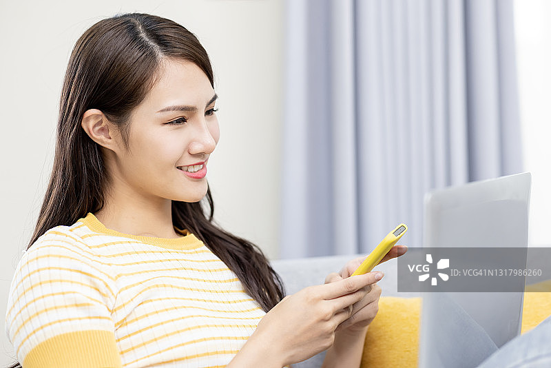 女人使用笔记本电脑和手机图片素材