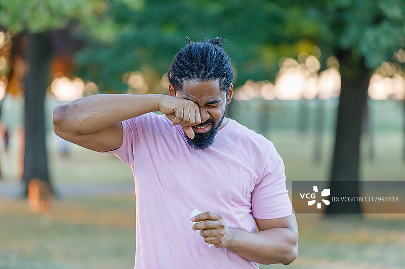 一位非裔美国男子在户外因过敏而感到不适图片素材