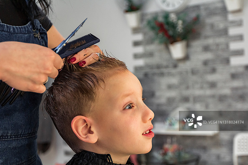 在理发店剪头发时害怕的小男孩图片素材