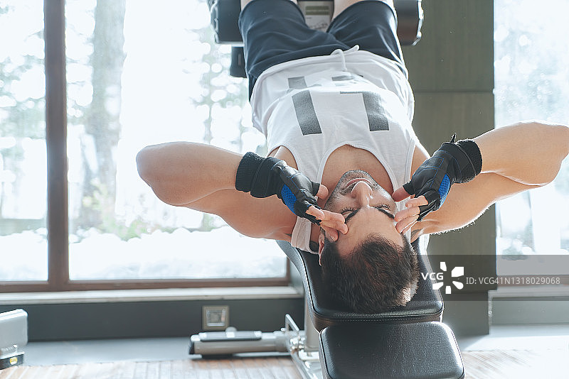 健身教练在健身俱乐部进行仰卧起坐图片素材