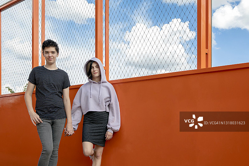 在橙色桥上牵着女友手的少年图片素材