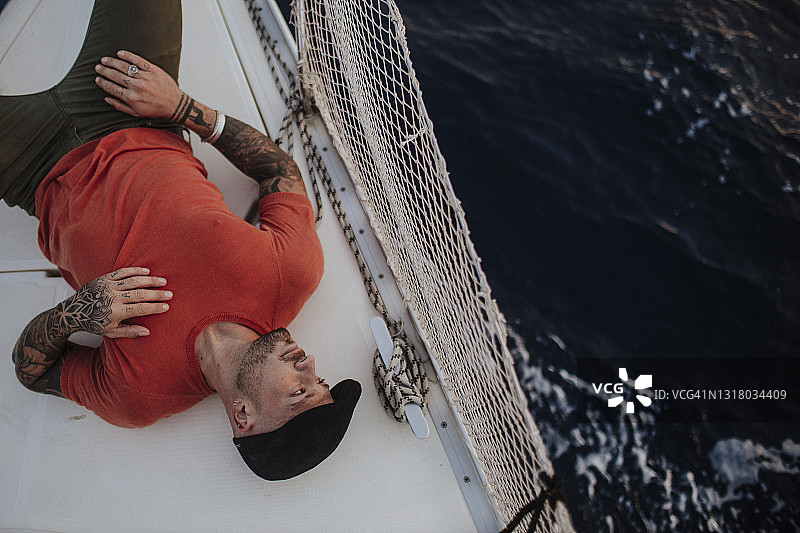 躺在海边船上的时尚男人图片素材