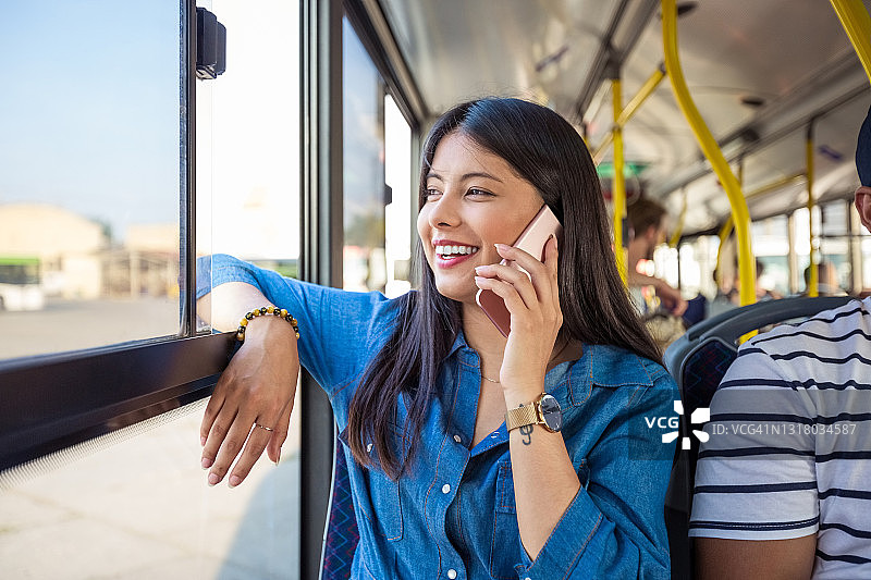 快乐的女人在公交车上打电话图片素材